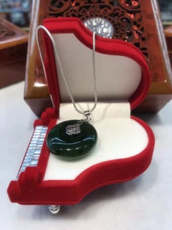 A green glass pendant sitting on top of a red box.