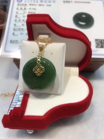 A green jade pendant sitting in a red box.