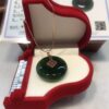 A green glass pendant sitting in a red box.