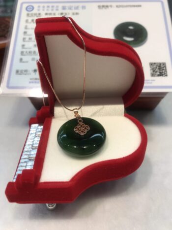 A green glass pendant sitting in a red box.