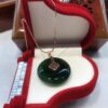 A green glass pendant sitting in a red box.