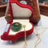 A piano shaped necklace in the shape of a green stone.