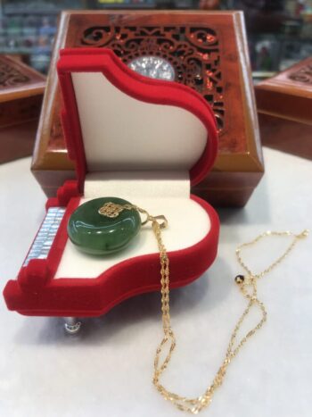 A piano shaped necklace in the shape of a green stone.