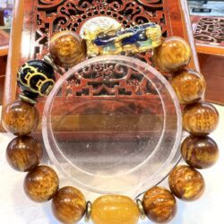 A large round bracelet with brown beads and a yellow bead.