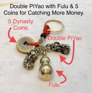 A key chain with five coins and two chinese characters.