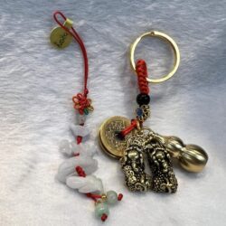 A key chain with a bell and two charms.