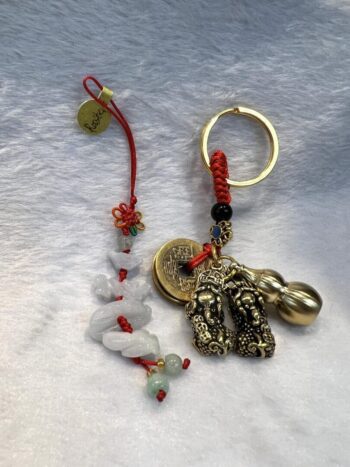 A key chain with a bell and two charms.