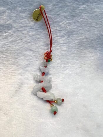 A red string of beads hanging on the snow.