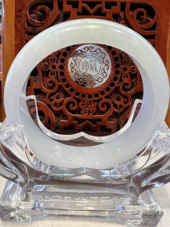 A white glass plate with a red wooden carving.