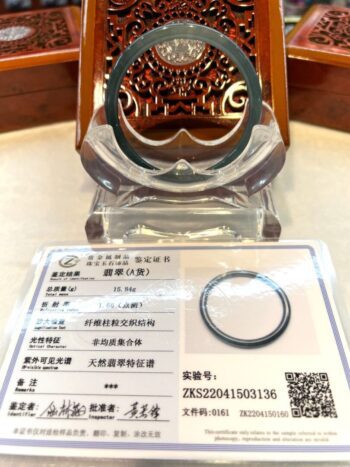 A glass display case with a metal ring and a certificate.