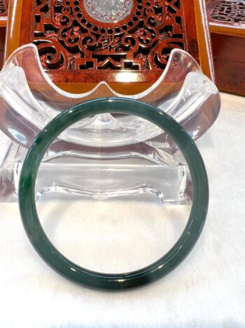 A green jade bangle sitting on top of a table.