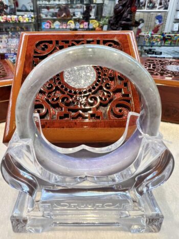 A clear glass chair with a wooden table in the background.