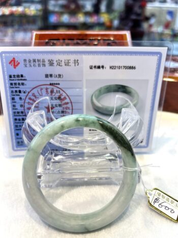 A green jade bangle is sitting on top of a table.