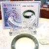 A green jade bangle sitting on top of a table.