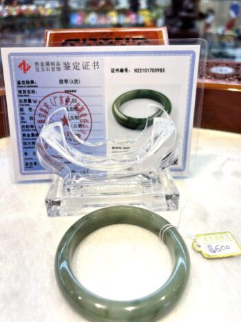 A green jade bangle sitting on top of a table.