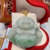 A green jade buddha sitting on top of a red box.
