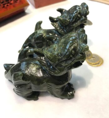 A green dragon statue sitting on top of a table.