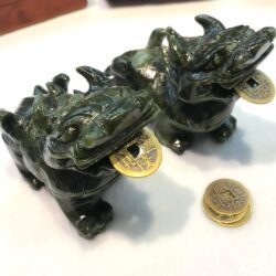 A pair of green dragons sitting on top of a table.