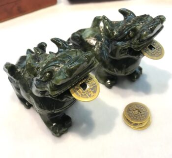 A pair of green dragons sitting on top of a table.