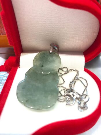 A green jade necklace in a red box.