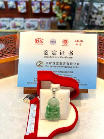 A green jade pendant sitting on top of a table.