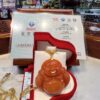 A red buddha statue sitting in a box.