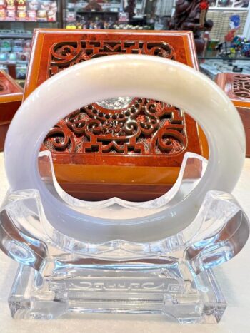 A white bangle sitting on top of a clear glass bowl.