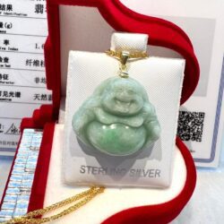 A green jade buddha is sitting in a red box.