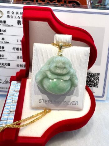 A green jade buddha is sitting in a red box.