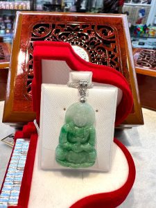 A green buddha statue sitting on top of a table.