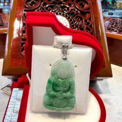 A green buddha statue sitting on top of a table.