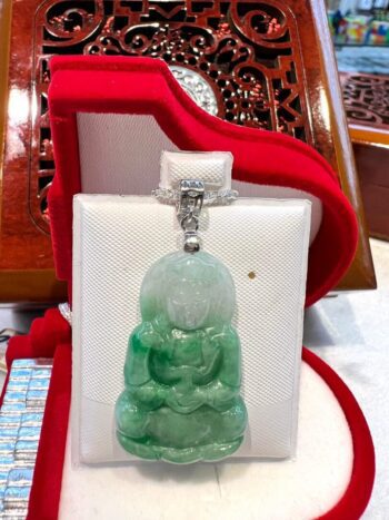 A green buddha statue sitting in a box.