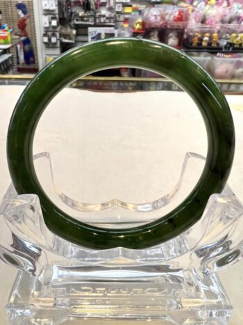 A green glass ring sitting on top of a clear glass vase.