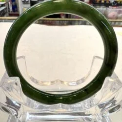 A green glass ring sitting on top of a clear glass vase.