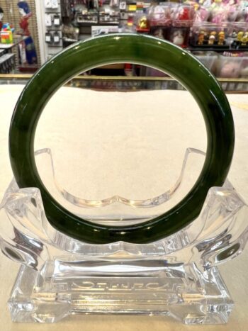 A green glass ring sitting on top of a clear glass vase.