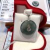 A green jade pendant sitting in a red box.