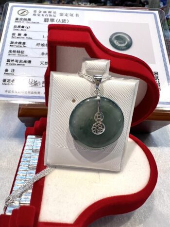 A green jade pendant sitting in a red box.