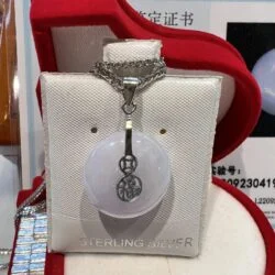 A white necklace with a silver chain and a pendant.