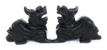 A pair of black carved wood animals sitting on top of each other.