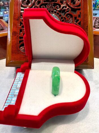 A green glass bead in the middle of a red box.