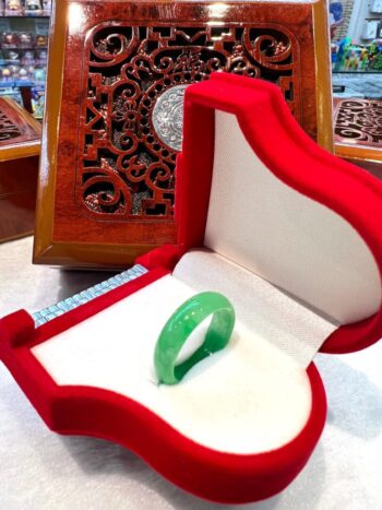 A green ring in a red box on top of a table.