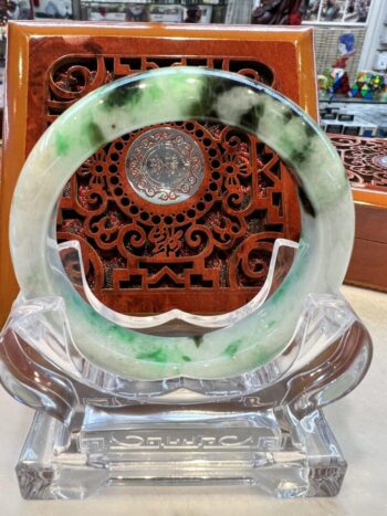 A green and white circular glass dish on display.