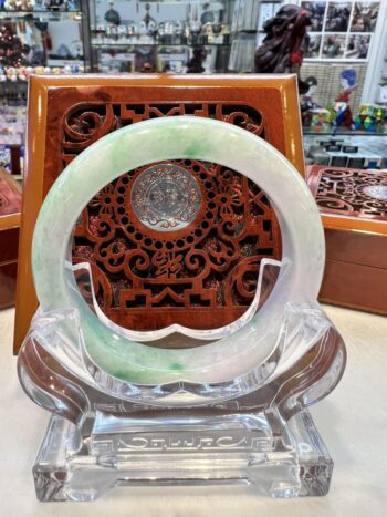 A green and white bangle sitting on top of a glass table.