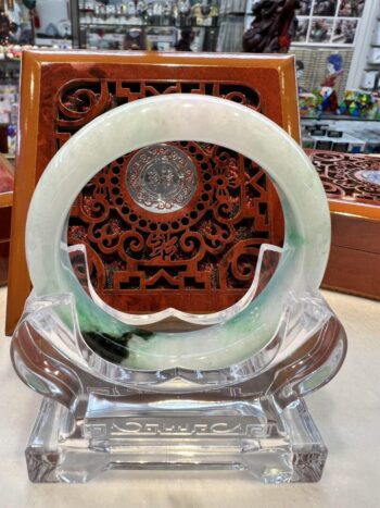 A green and white circular glass dish on display.