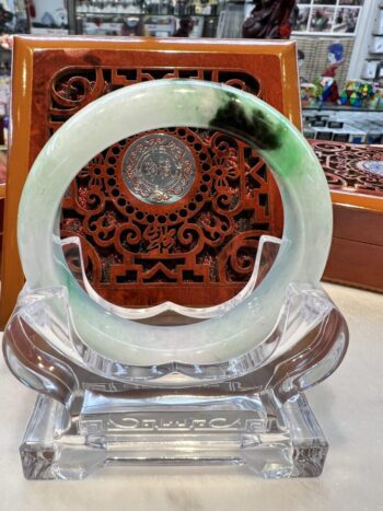 A green and white circular glass dish on display.