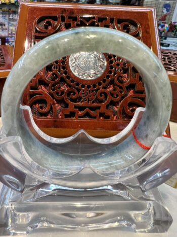 A circular glass plate with a carved wooden design.