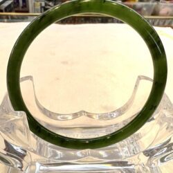 A green glass ring sitting on top of a clear bowl.