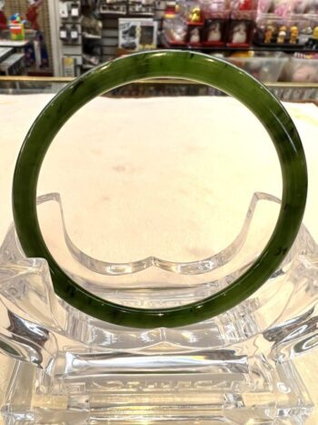 A green glass ring sitting on top of a clear bowl.