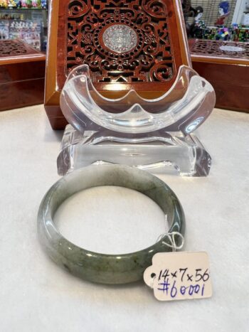 A green jade bangle sitting on top of a table.