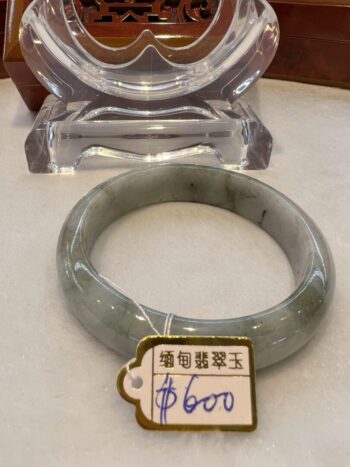 A green jade bangle sitting on top of a table.